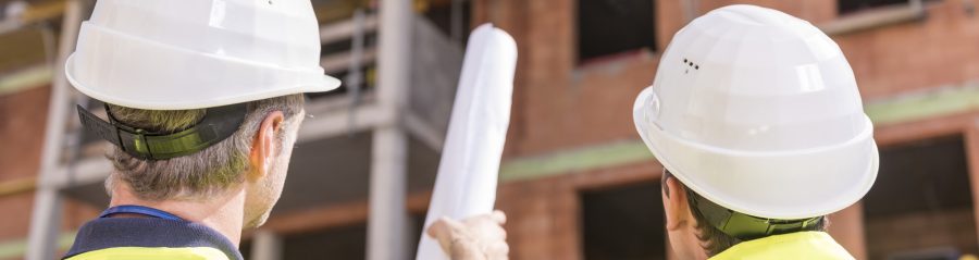 Builder pointing at building shell with blueprint