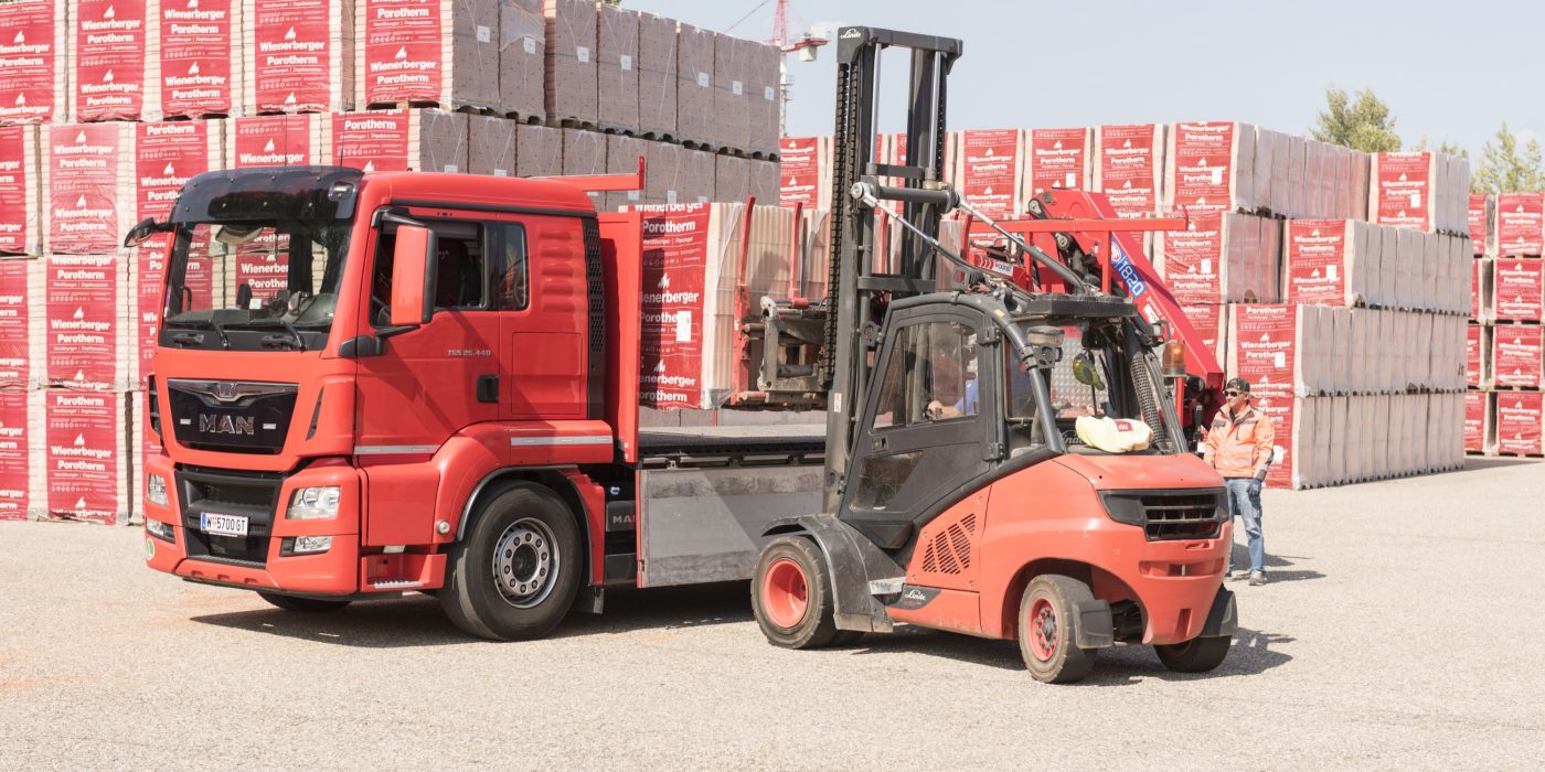 Forklift loads clay block pallets onto truck at stockyard