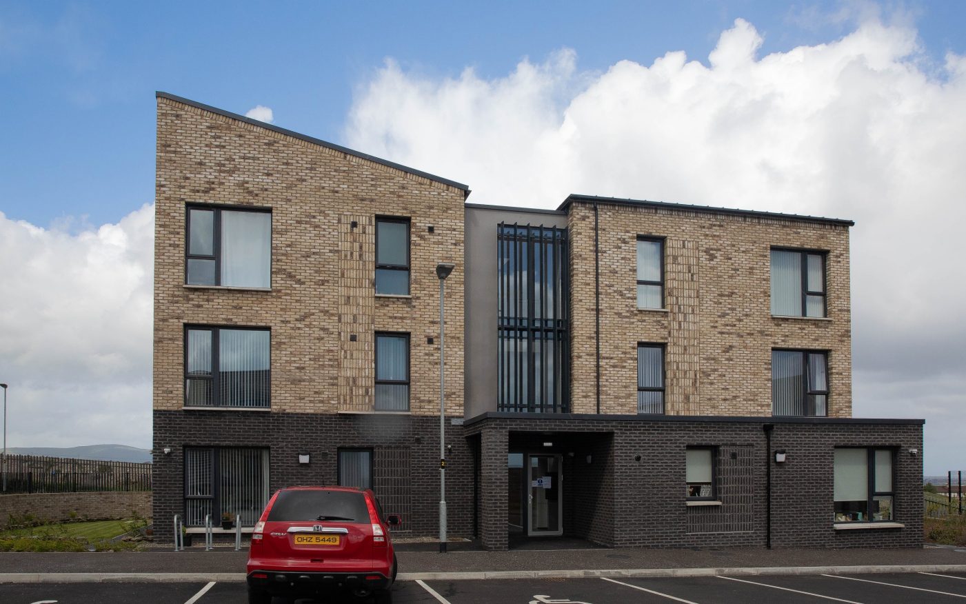 Three apartment building with parking spaces in front