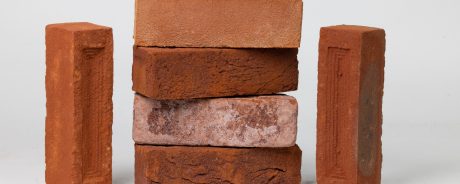 Stacked red clay bricks with a white background
