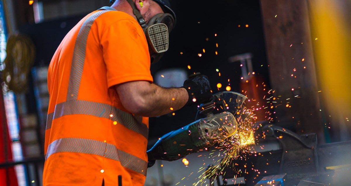 Two men in safety gear standing at lake edge