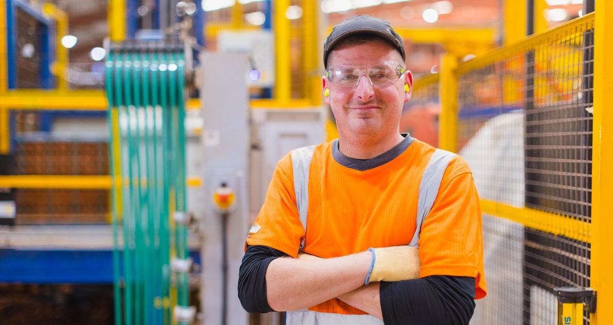 Man in protective clothing inspecting roof tiles