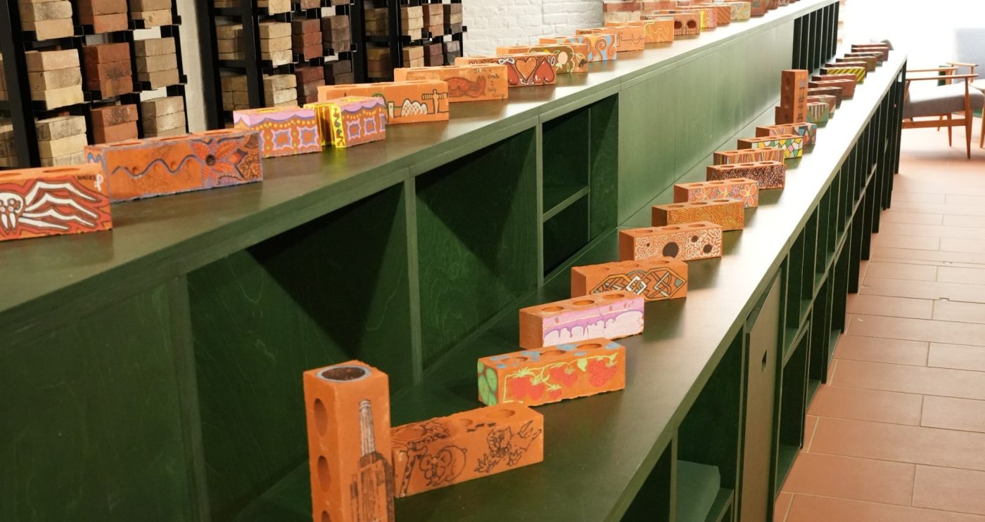 Bricks arranged in a long row featuring decorative designs created by architects