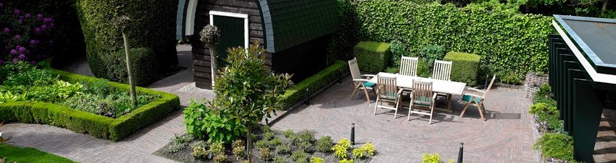 Al fresco dining area with clay paved patio and modern garden shed