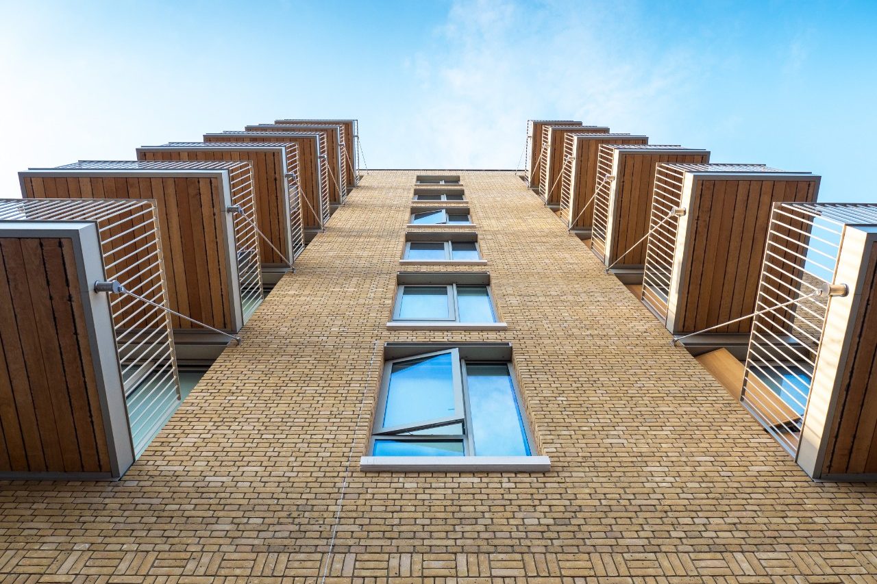 Looking up at brick apartment building with balconies