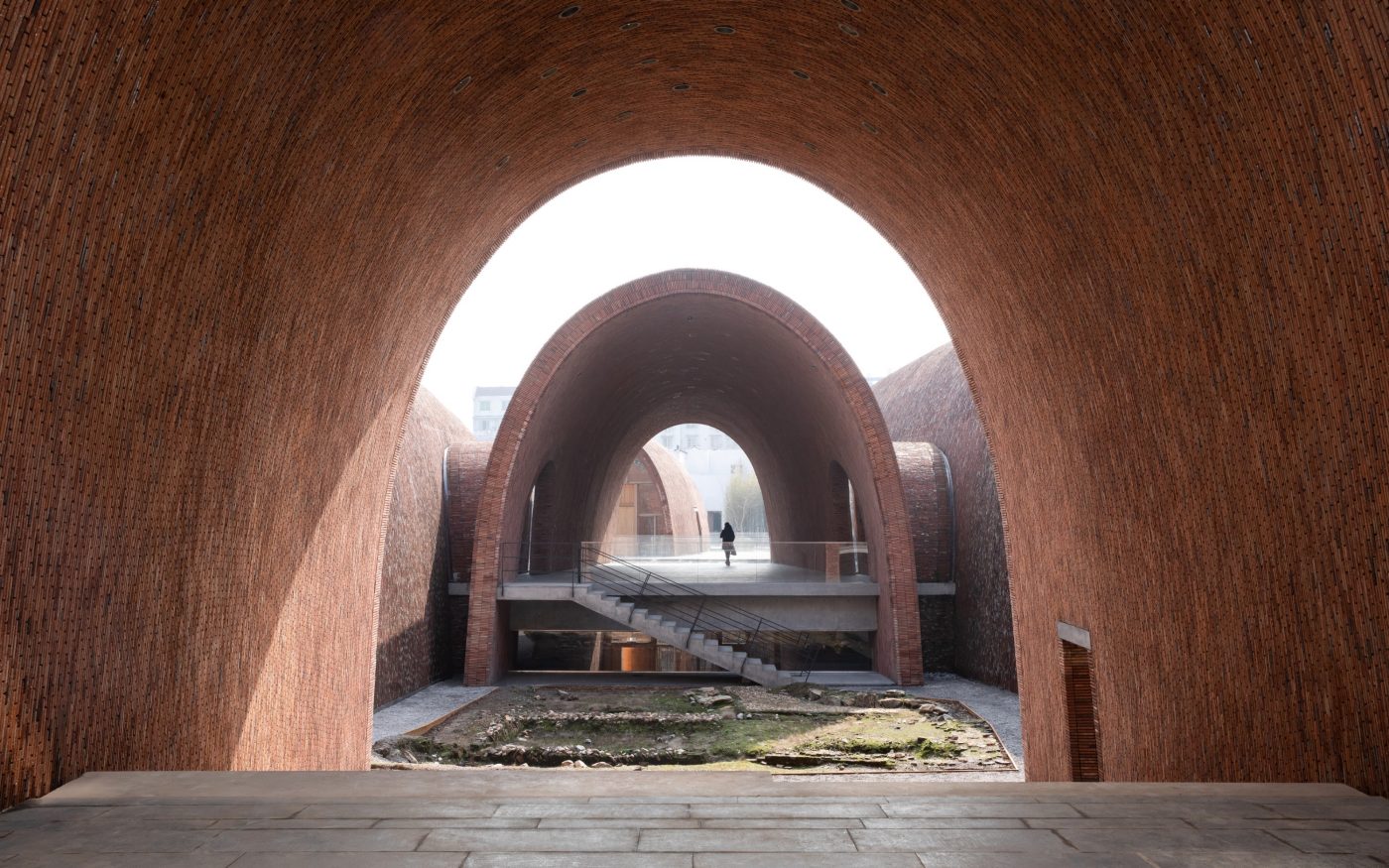 Vaulted brick building at Kiln Museum, leading to outdoor garden space