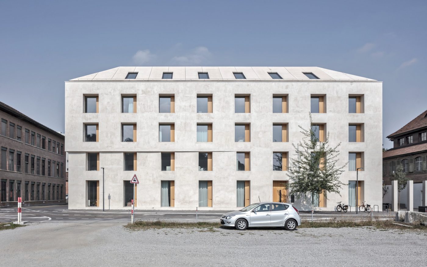 Modern light grey brick residential building beside canal