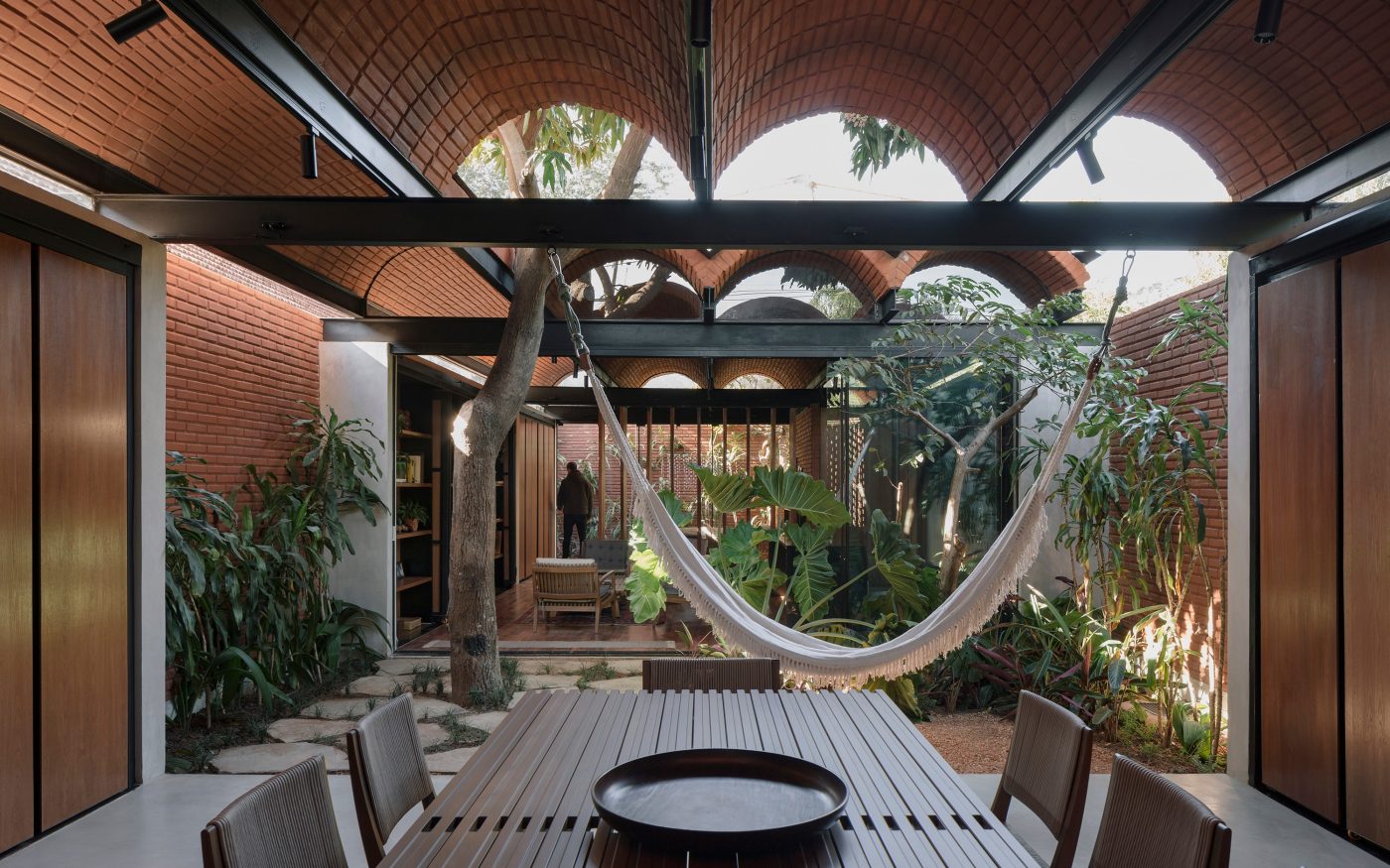 Dining table with view of hammock and courtyard in modern house