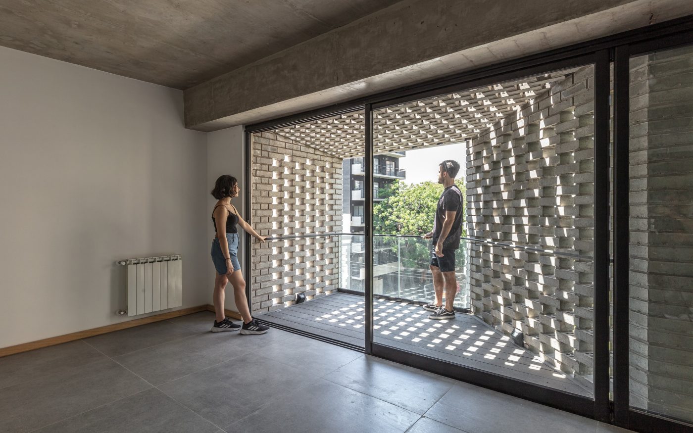 Man and woman inside apartment with balcony