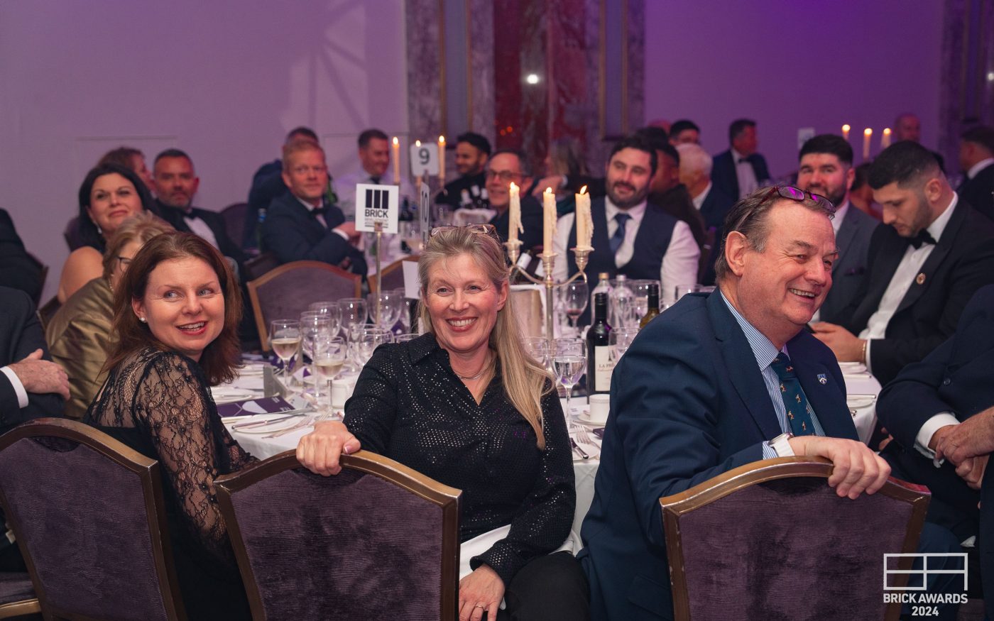 smiling faces of attendees around a table at the awards evening