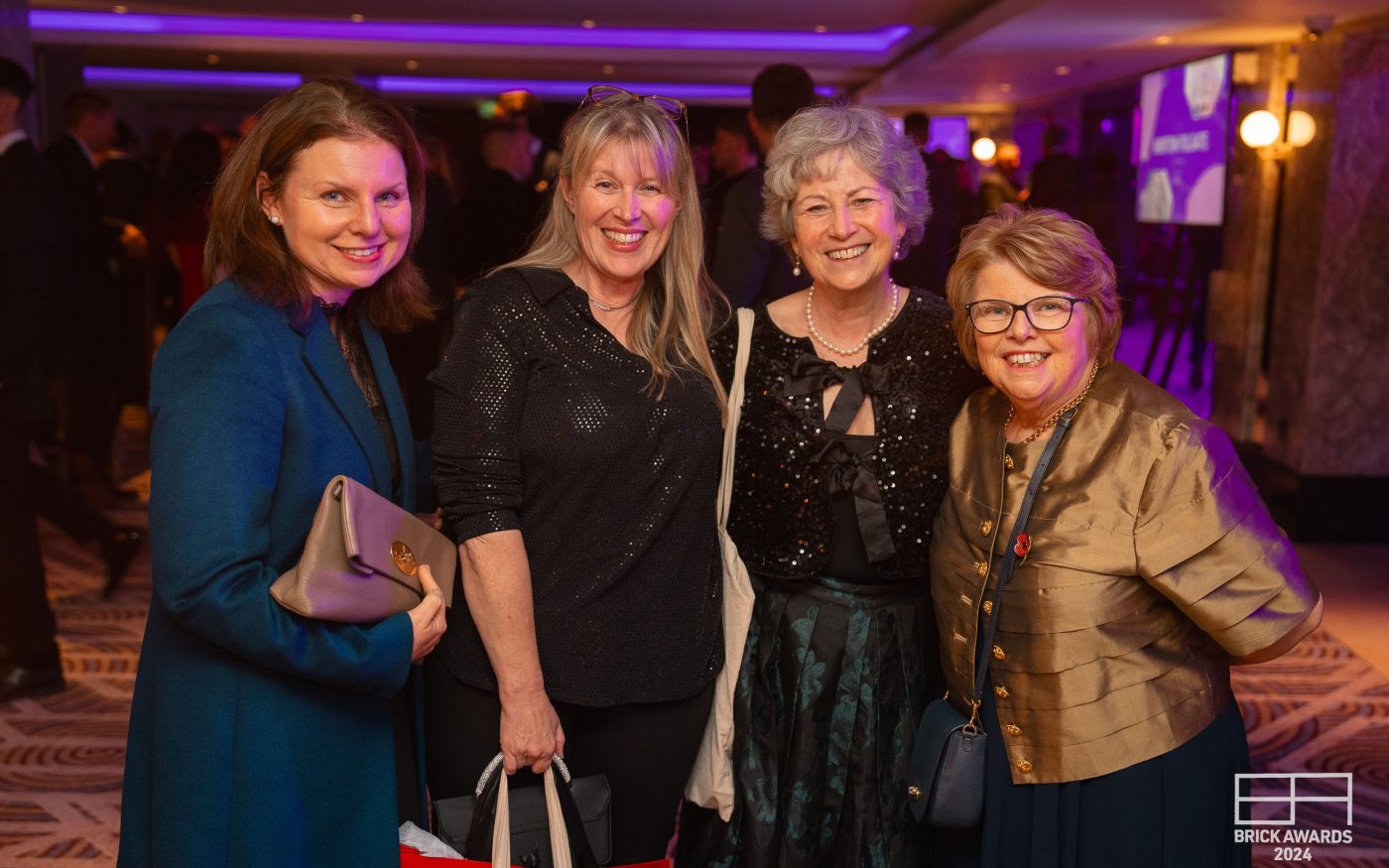 4 women posing for a photo smiling