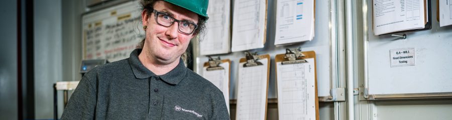 Image of a man in a hard hat holding a brick