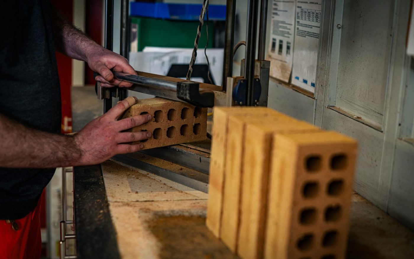 Close up image of a man measuring bricks