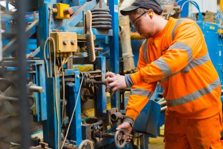 Man focusing on a piece of machinery in the factory