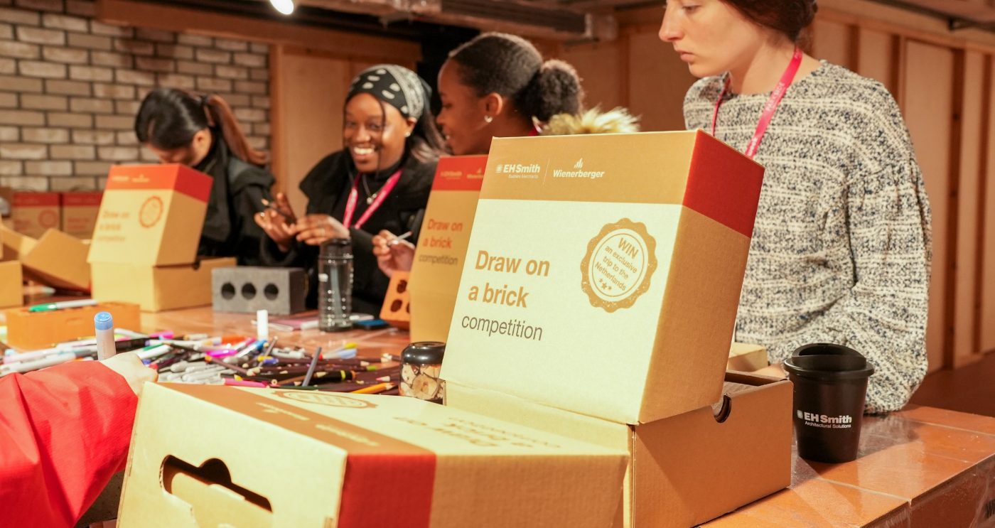 4 girls stood at a table drawing on bricks
