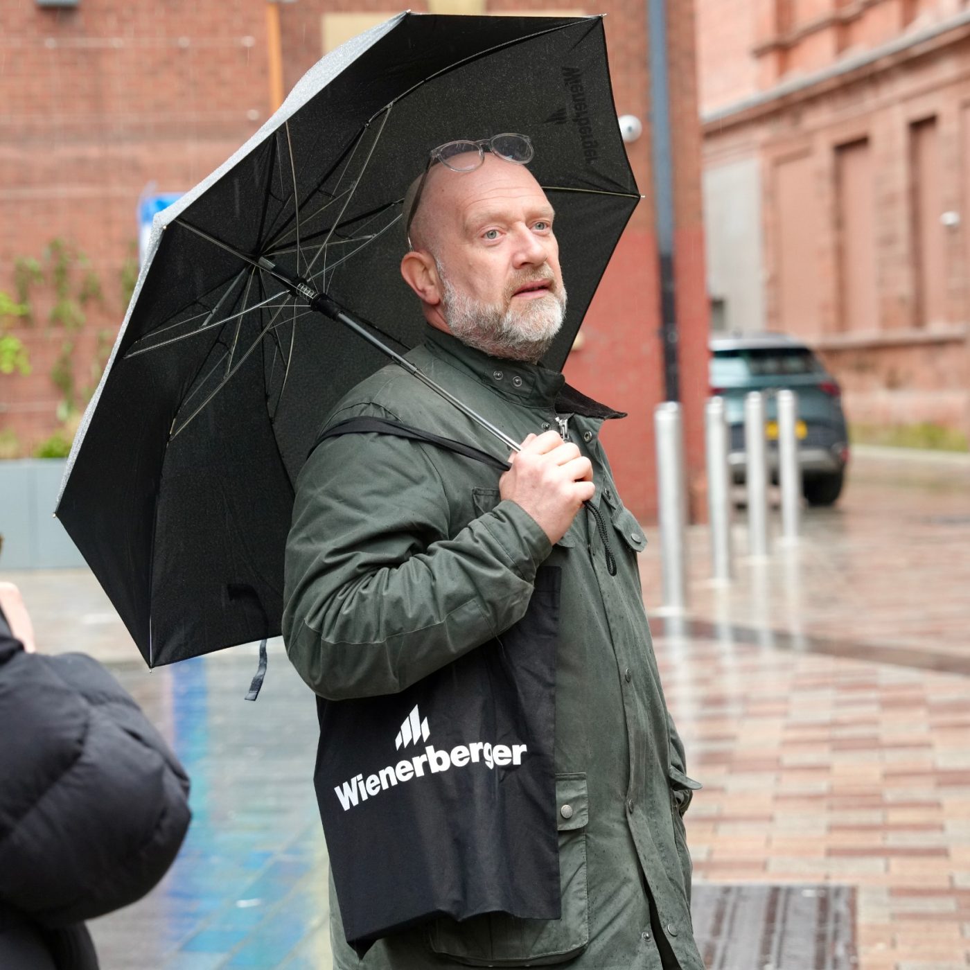 Man with a Wienerberger bag holding an unbrella