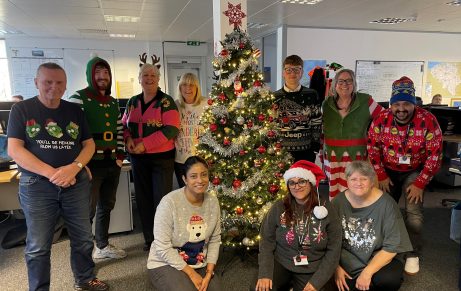 wienerberger collegaues smiling next to christmas tree on christmas jumper day
