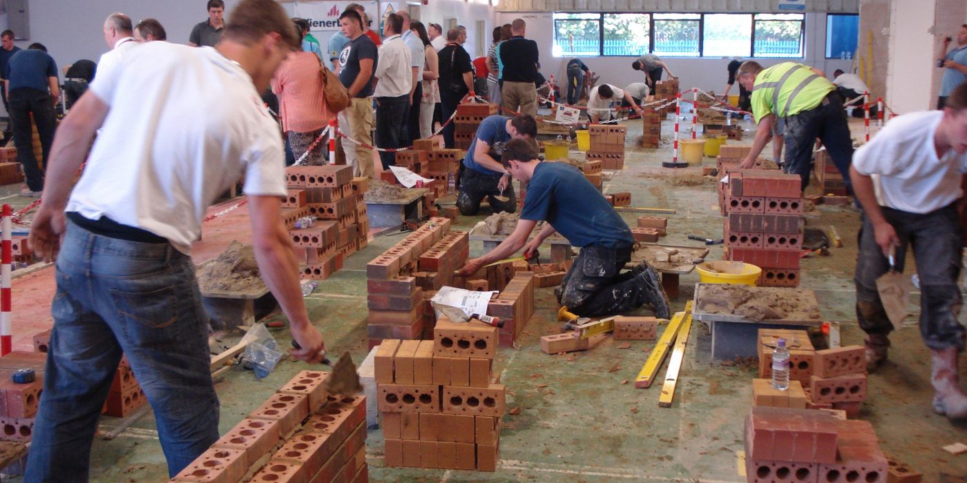 Guild of Bricklayer competitors laying bricks inside workspace
