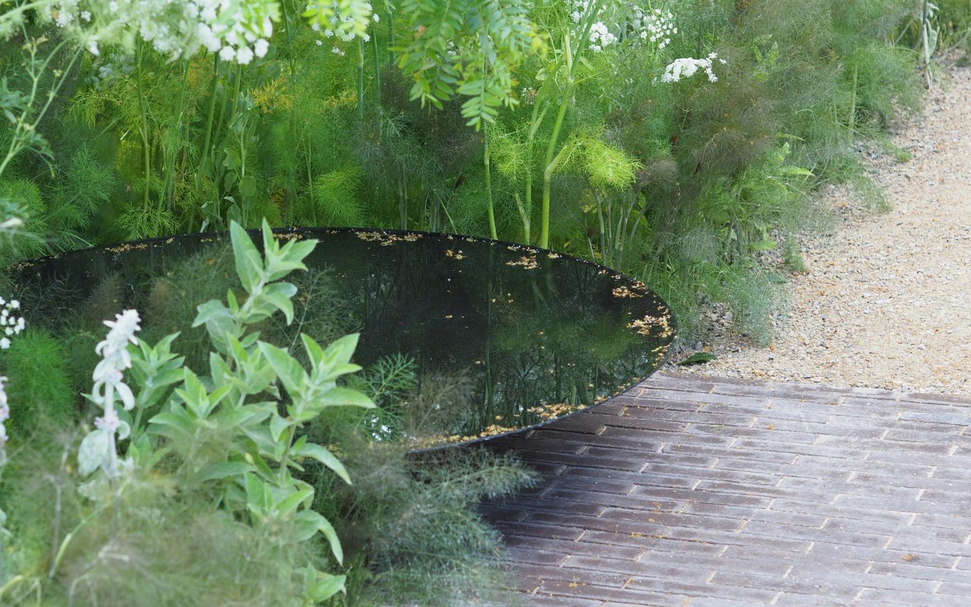 water feature in a garden next to the path