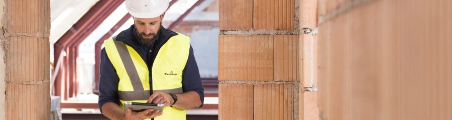 Man on construction site looking at tablet