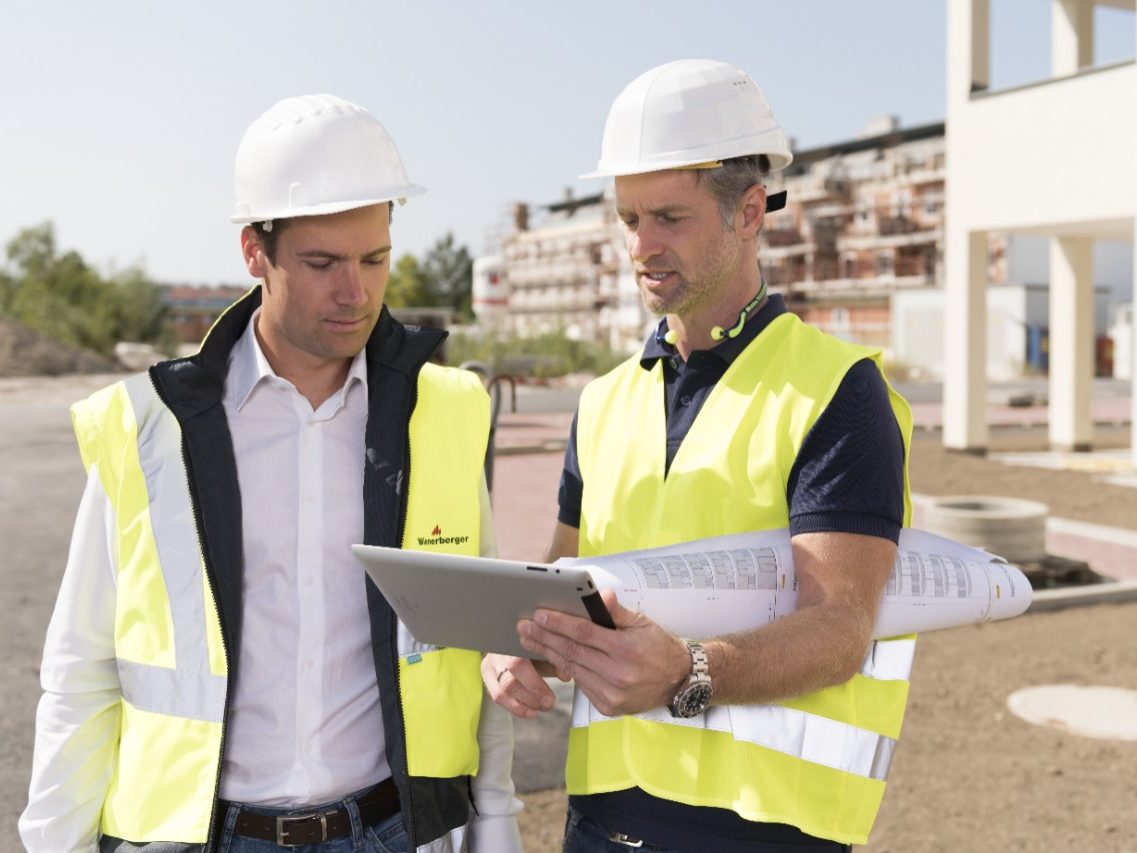 Building professionals looking at tablet at construction site