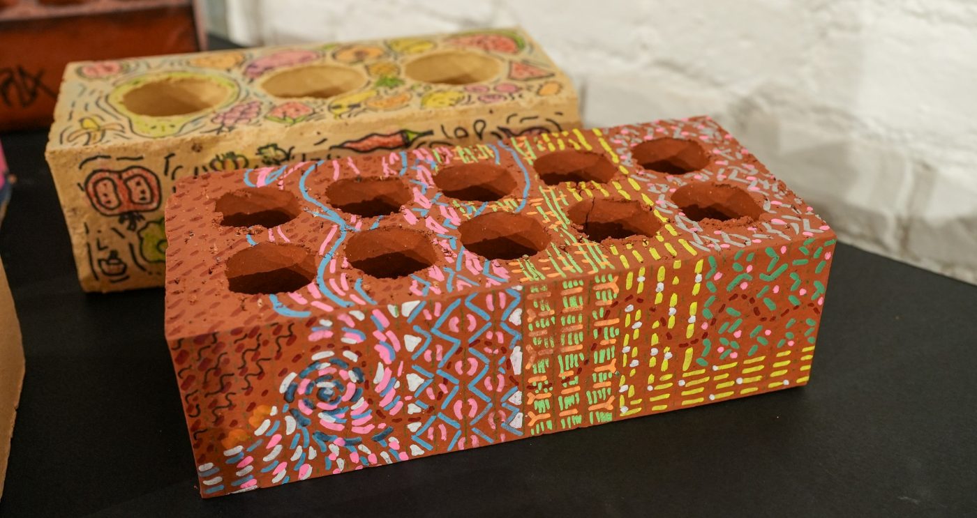 Two beautifully decorated bricks with bright colours