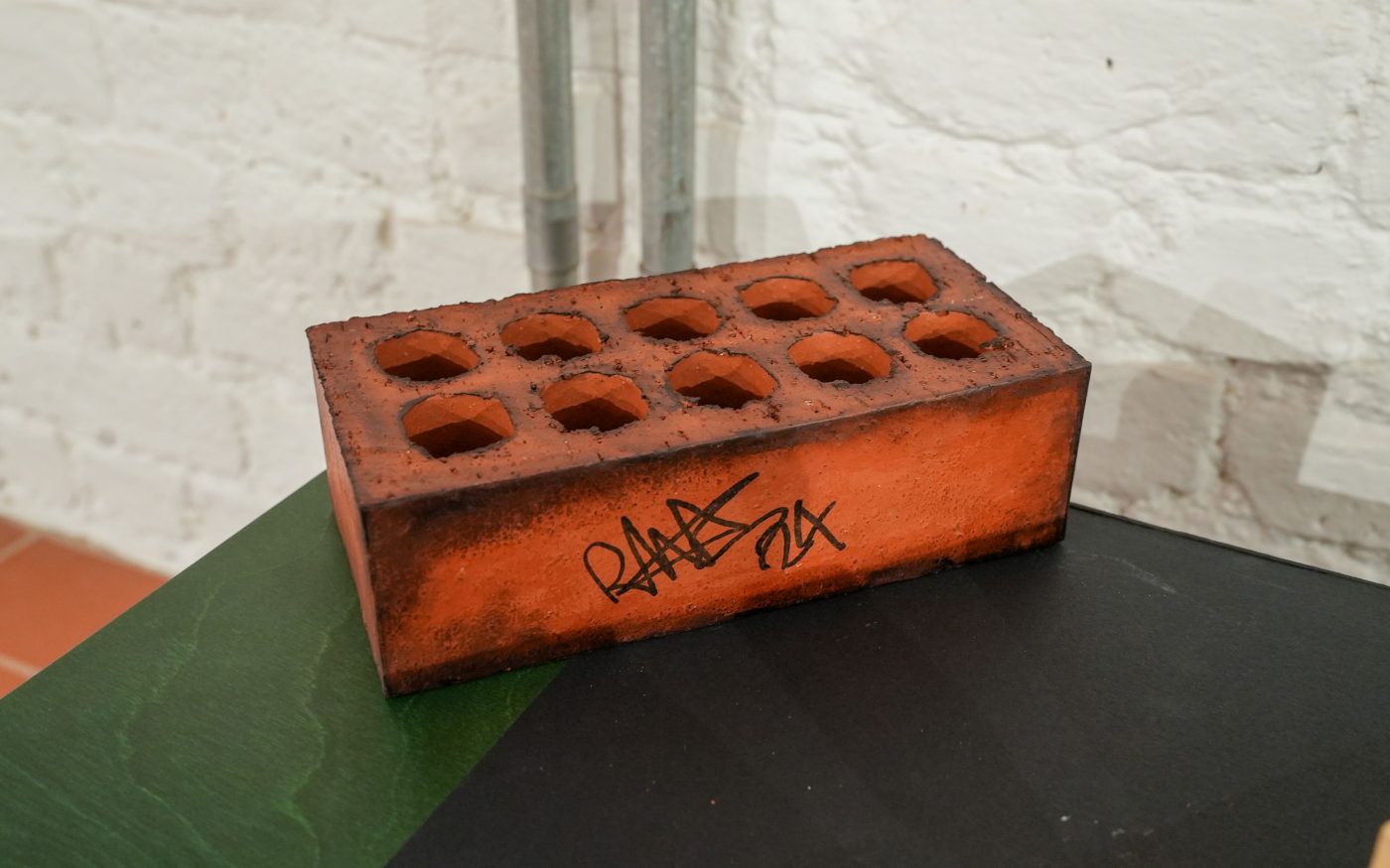 rustic designed red brick with graffiti style writing on it