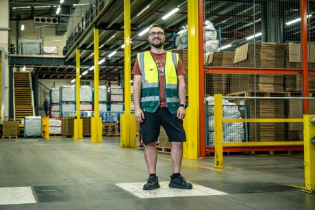 Gabriel standing in the warehouse smiling towards the camera