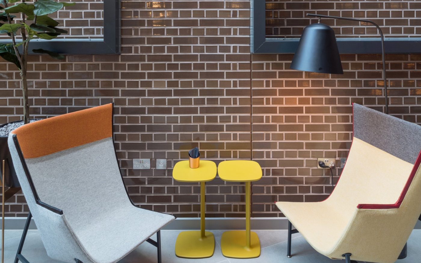 Interior of Yotel lobby with chairs and glazed brick wall