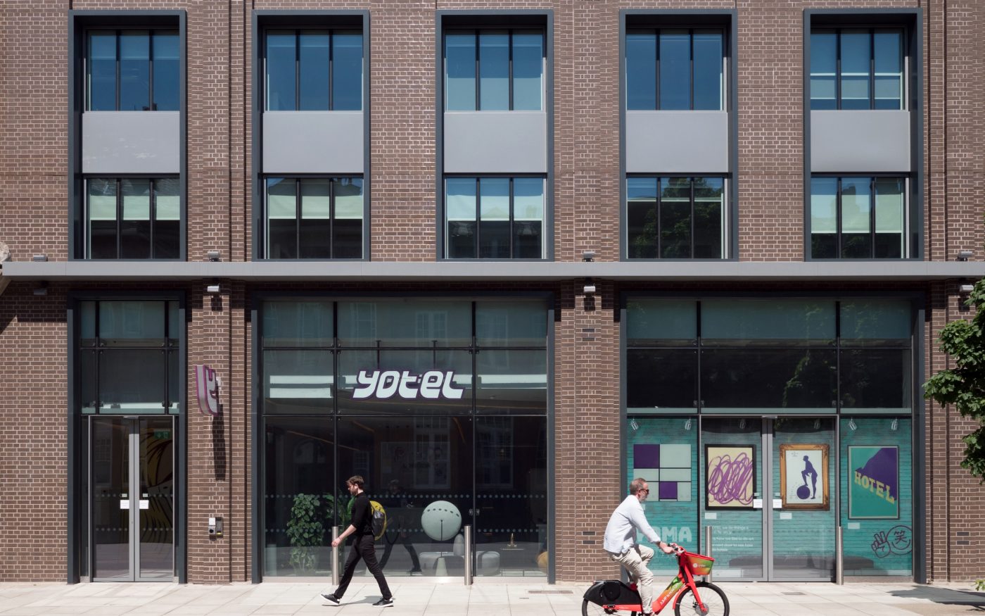 Pedestrian and cyclist outside Yotel exterior