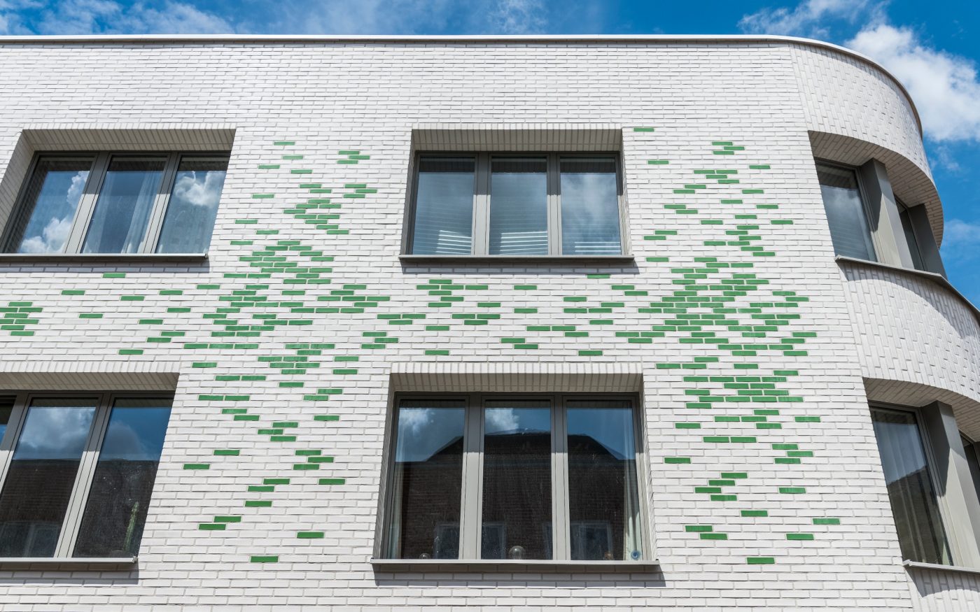 Pharmacy exterior facade in white and green glazed bricks