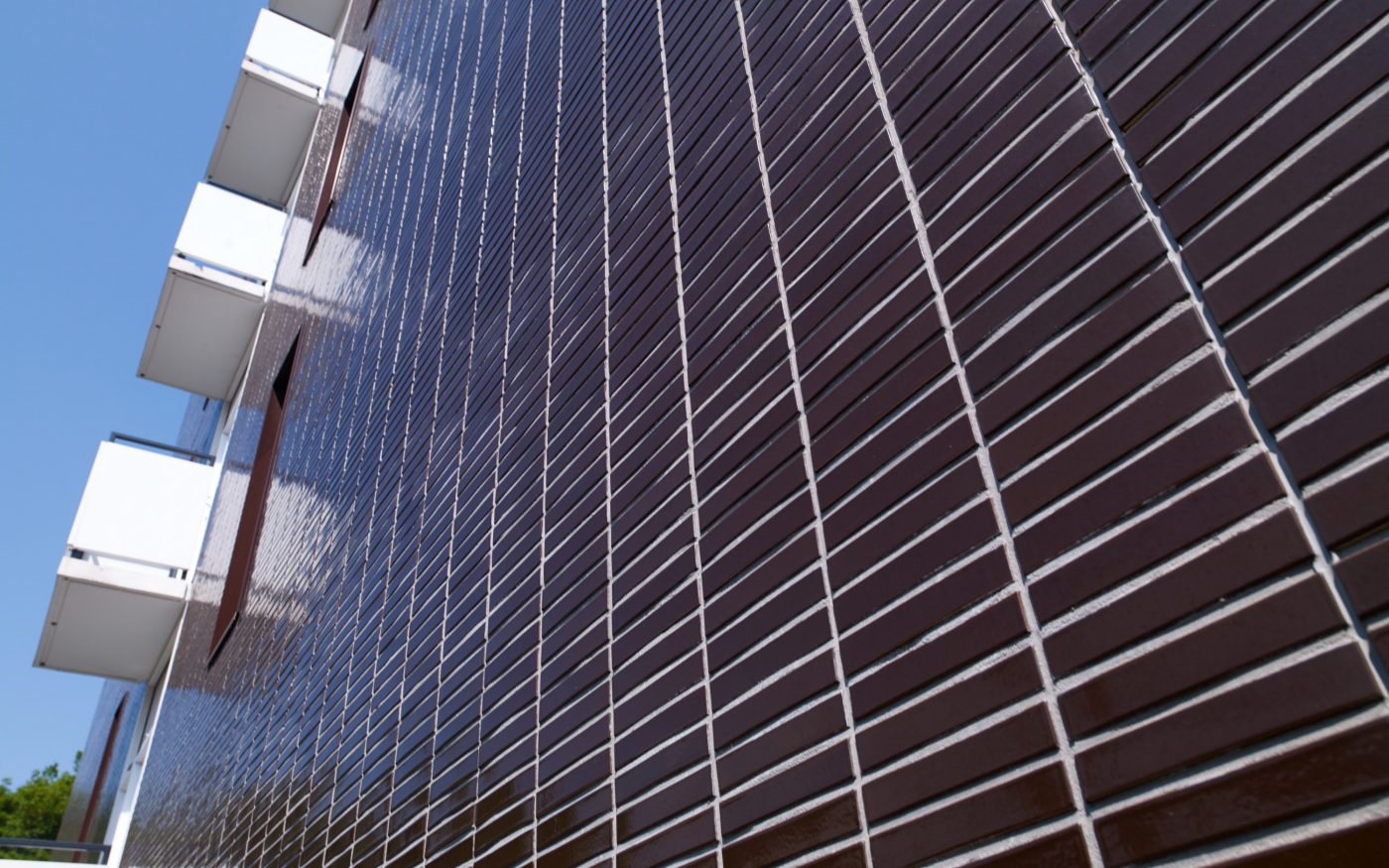 Dark brown glazed bricks laid in stack bond