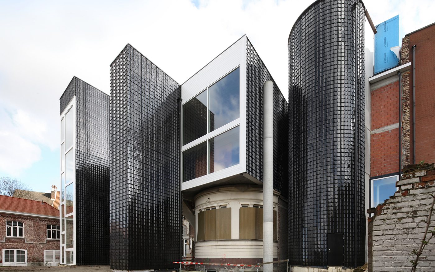 Contemporary building facade featuring high shine black glazed bricks