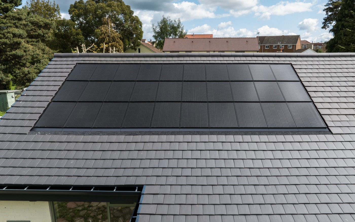 Close up of a grey tiled roof and solar panels