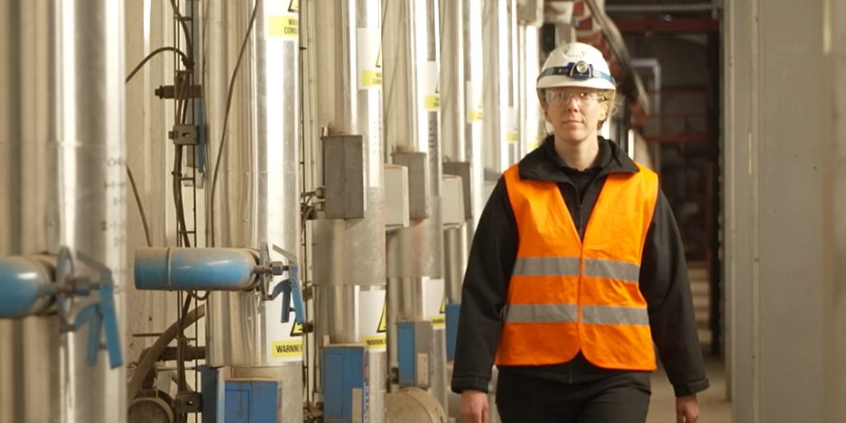 Emilande Renard walking through factory in PPE