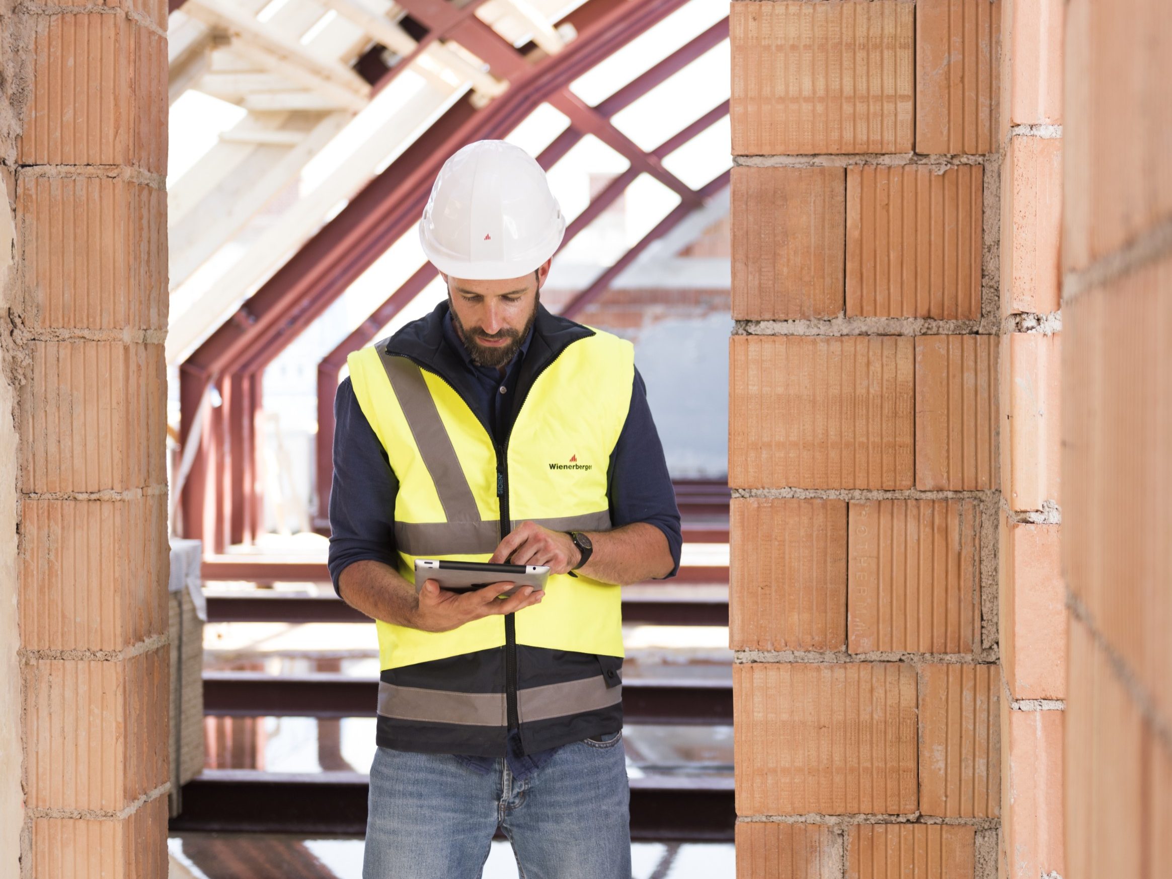Product manager standing in attic under renovation checking tablet