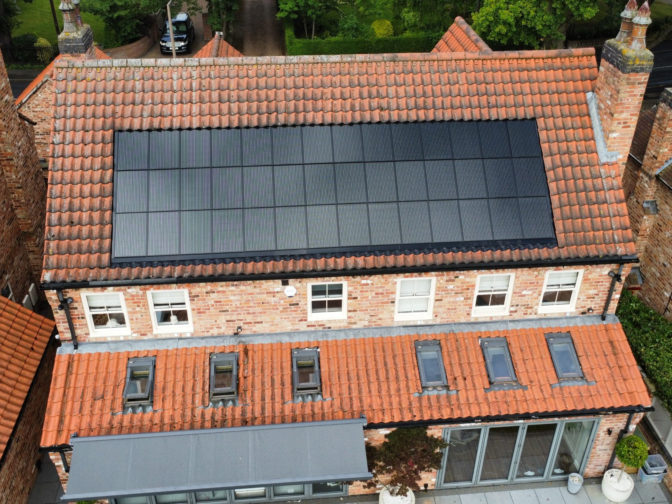 Aerial view of in-roof solar array on large house