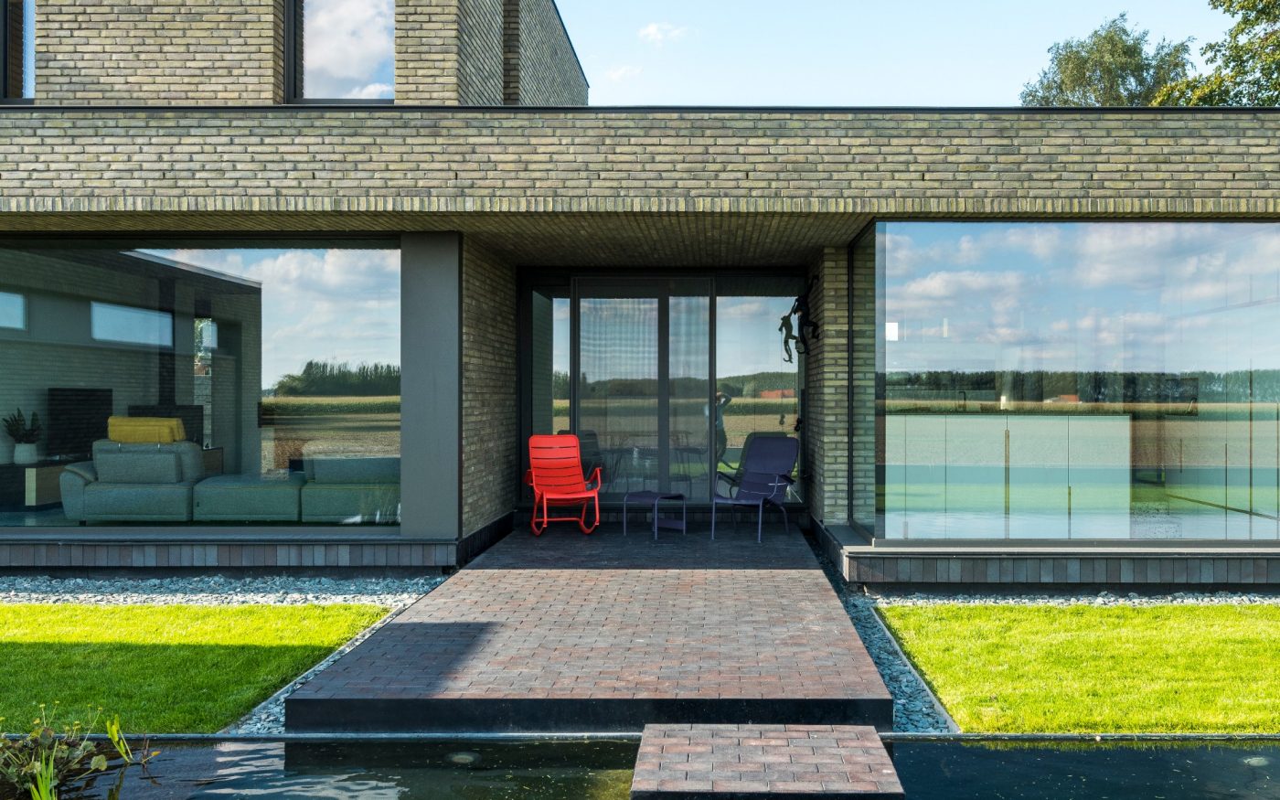 Shot showing paved path in front of home, alongside green garden