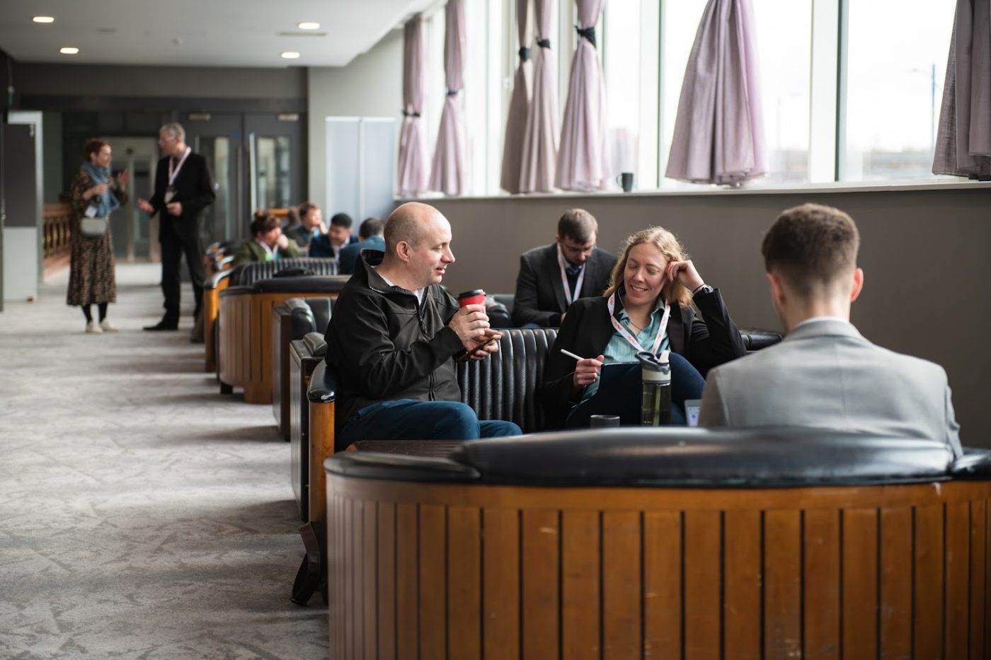 three people sat in a booth at a conference