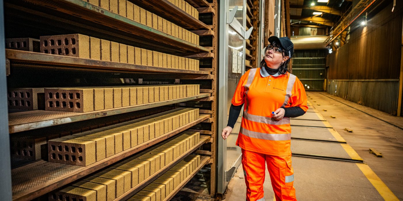 Image of a woman in construction checking bricks