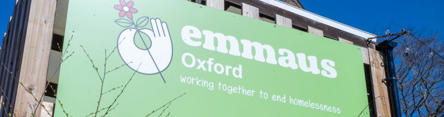 Large green sign on building with Emmaus brand logo