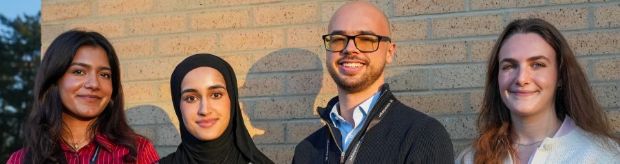 Finance apprentice team photo against a buff brick wall