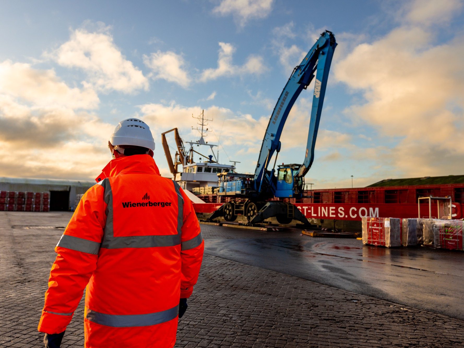 Man in Wienerberger high viz jacket walking through port