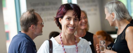Portrait image of Livia with people talking in the background