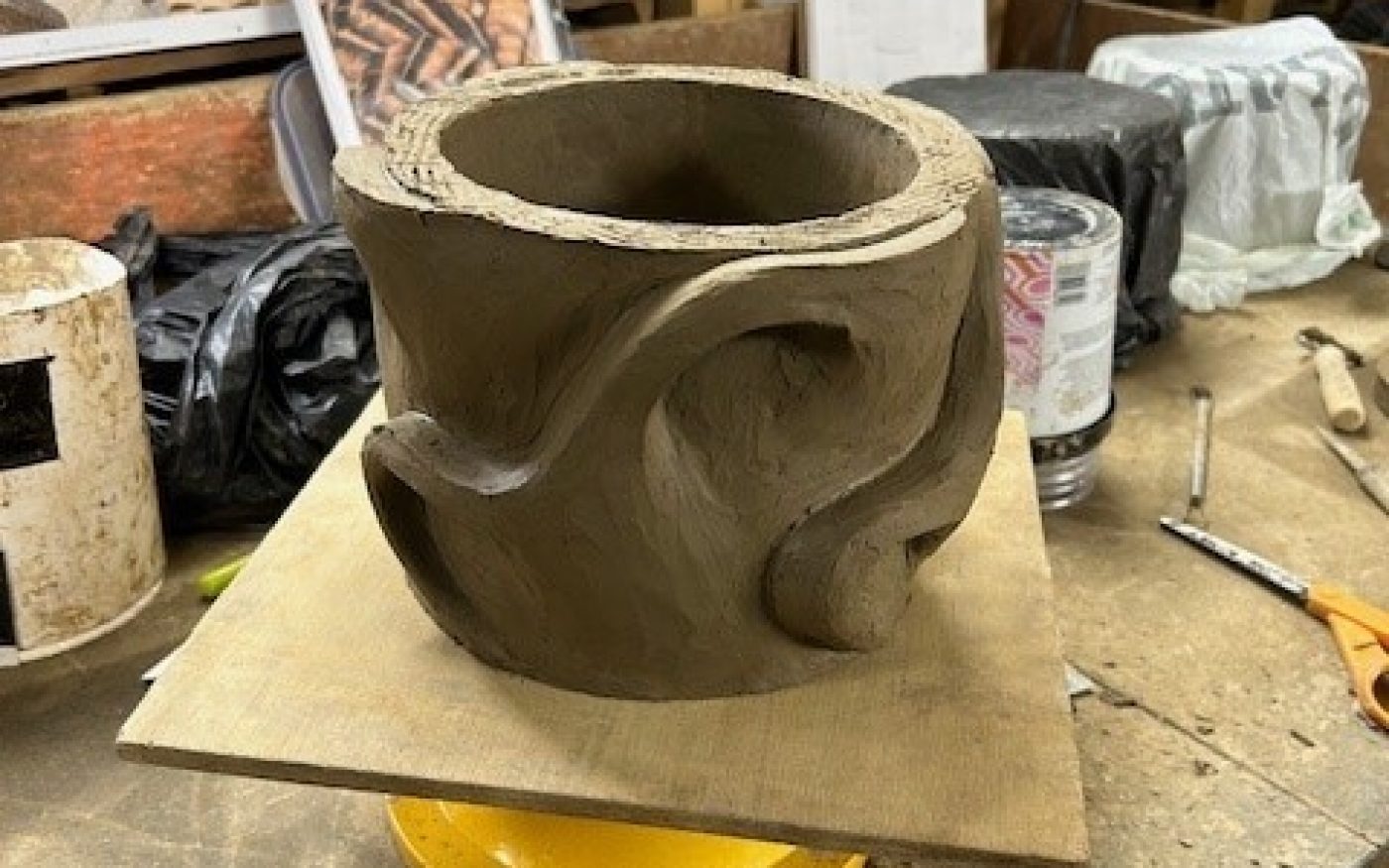 Clay cylinder sculpture with swirts round the sides