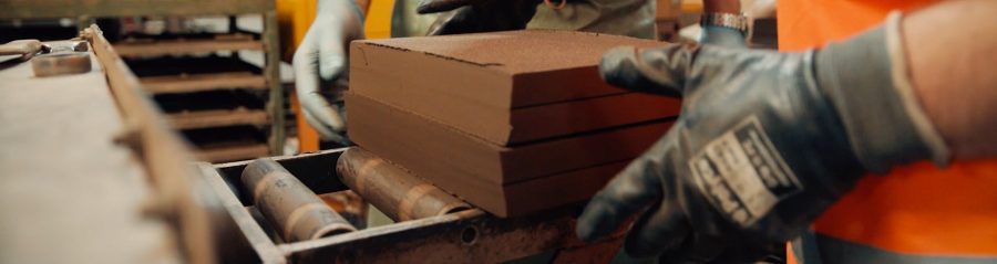 Man handling clay tiles in Wienerberger factory