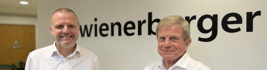 Simon Nevitt and Keith Barker smiling in front of a wienerberger logo