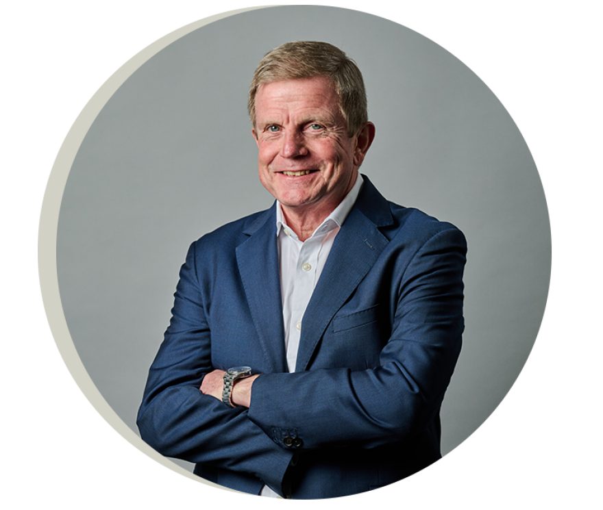 Keith Barker smiling crossed arms towards a camera
