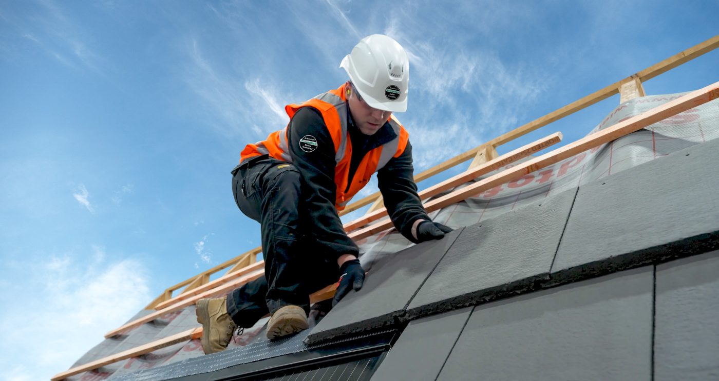 Man installing solar panels with blue sky in the back ground