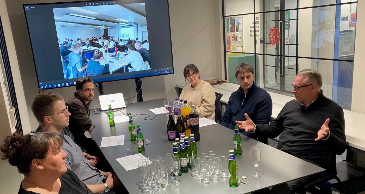 Architecture students sat round a table taking part in a discussion